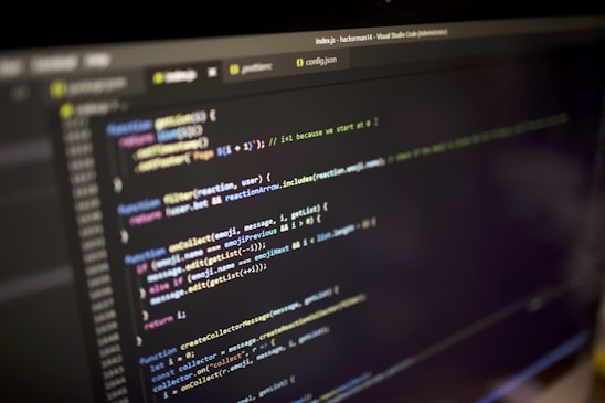 Close-up view of a computer screen displaying a code editor with JavaScript code. The code is color-coded, showing various functions, variables, and comments. The editor interface includes tabs and a menu bar, indicating an active coding session.