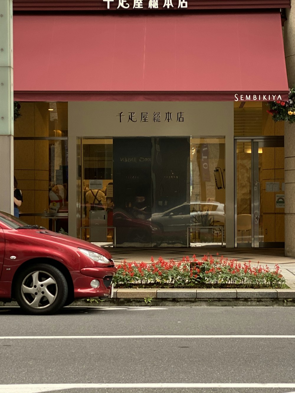 coche rojo aparcado frente al restaurante UNKs