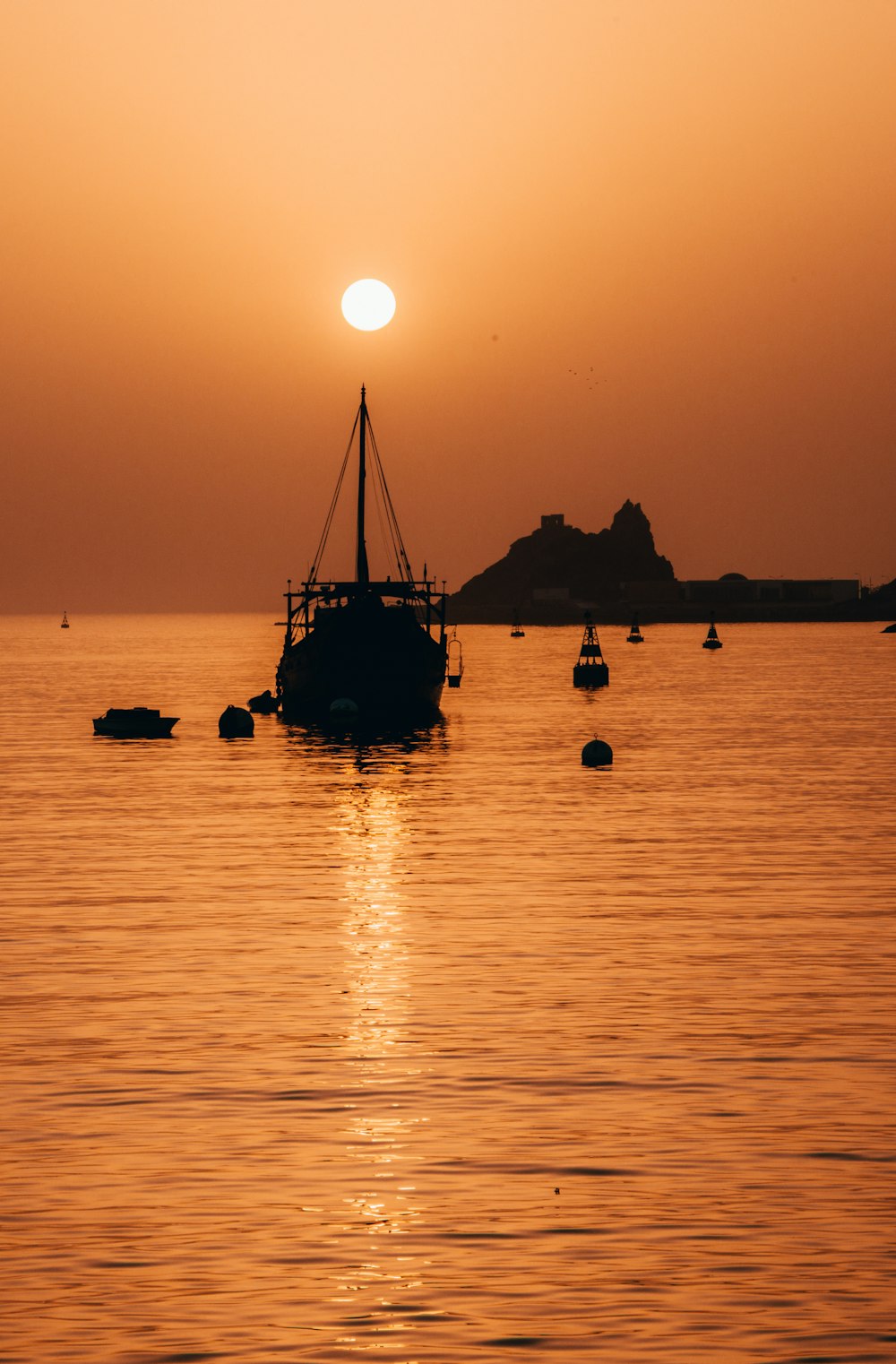 silhouette of boat on sea during sunset