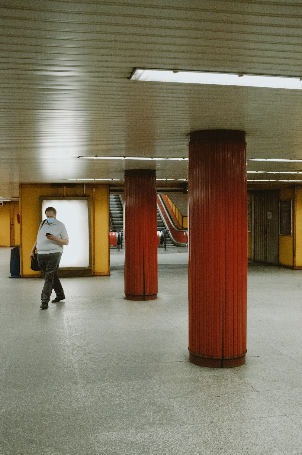 man in white dress shirt and black pants standing near red posts