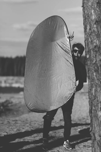grayscale photo of person holding umbrella