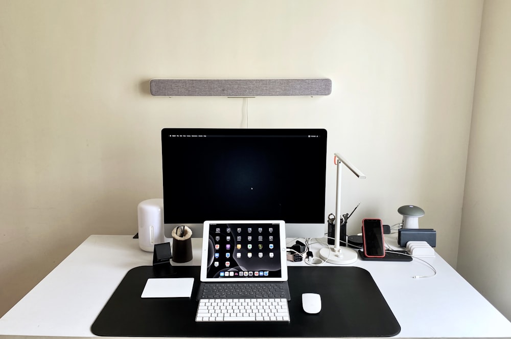black flat screen computer monitor on white wooden desk