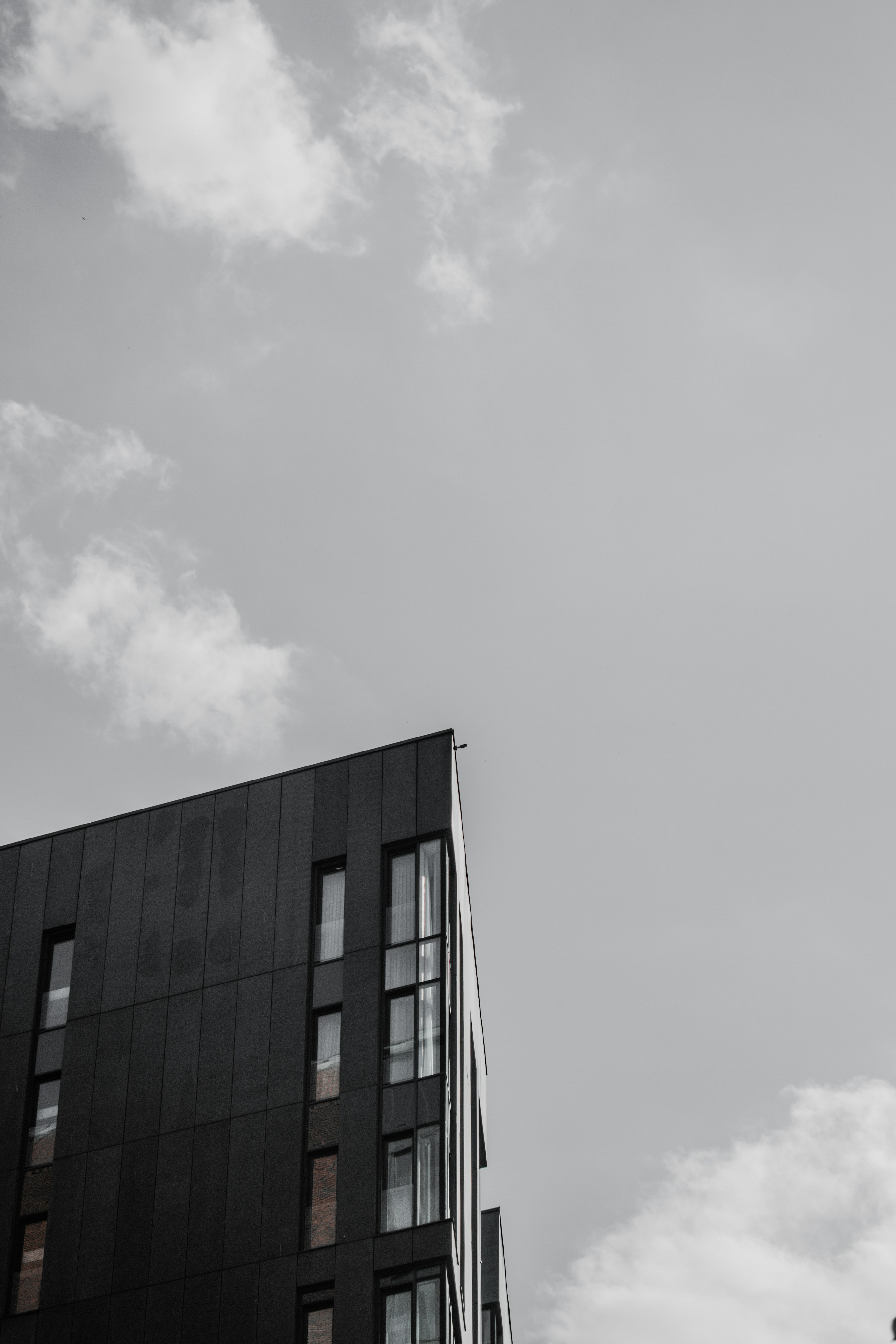 black concrete building under white clouds during daytime
