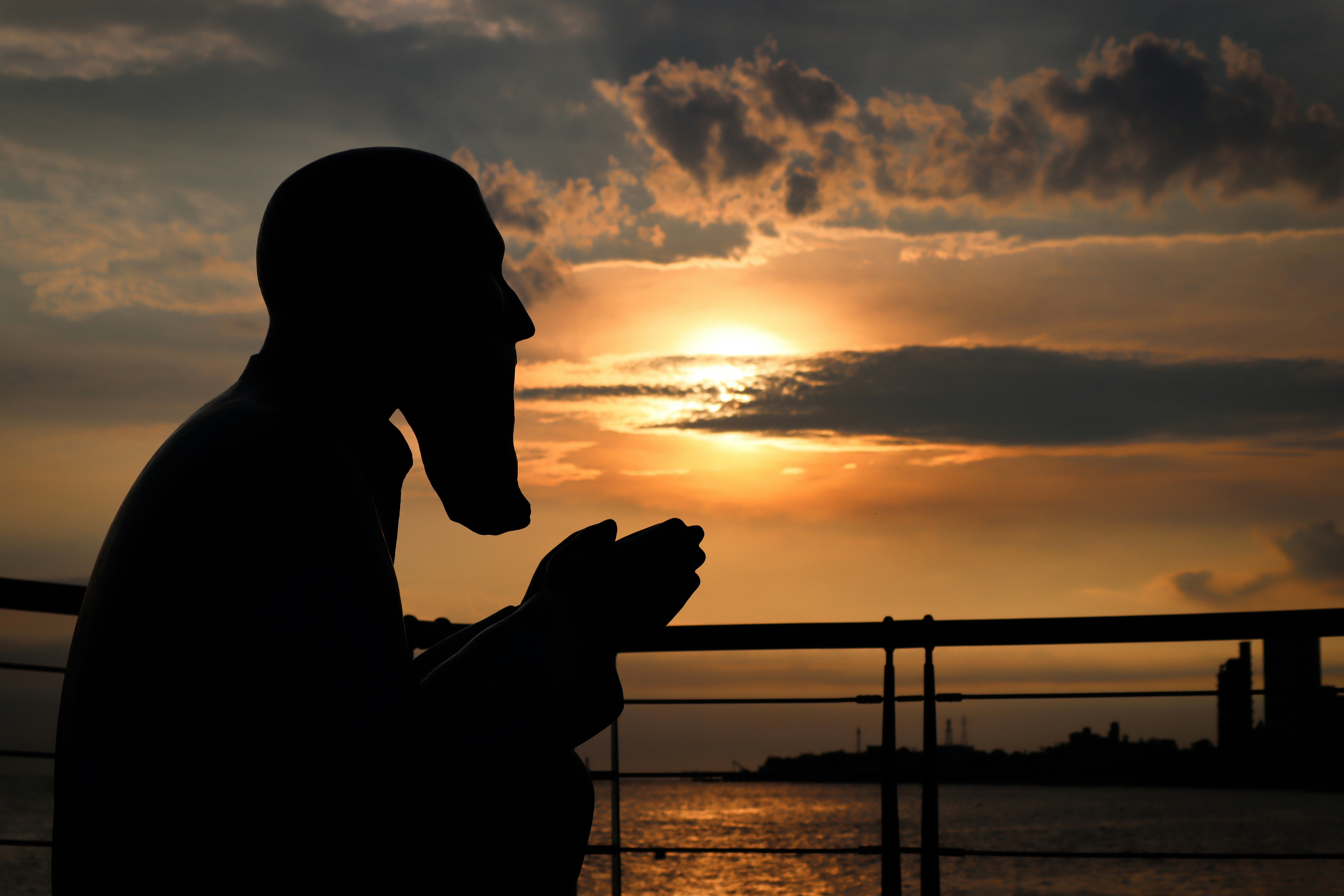 silhouette of man holding camera during sunset
