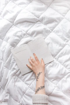 Close-up of hands gently holding an open journal with handwritten notes