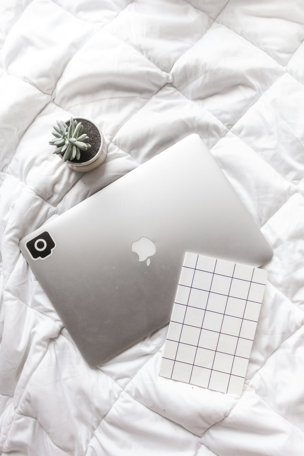 silver macbook on white and gray floral textile