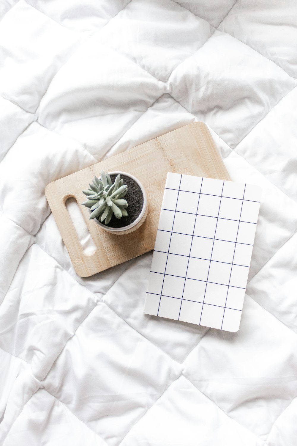 white and brown book on white textile