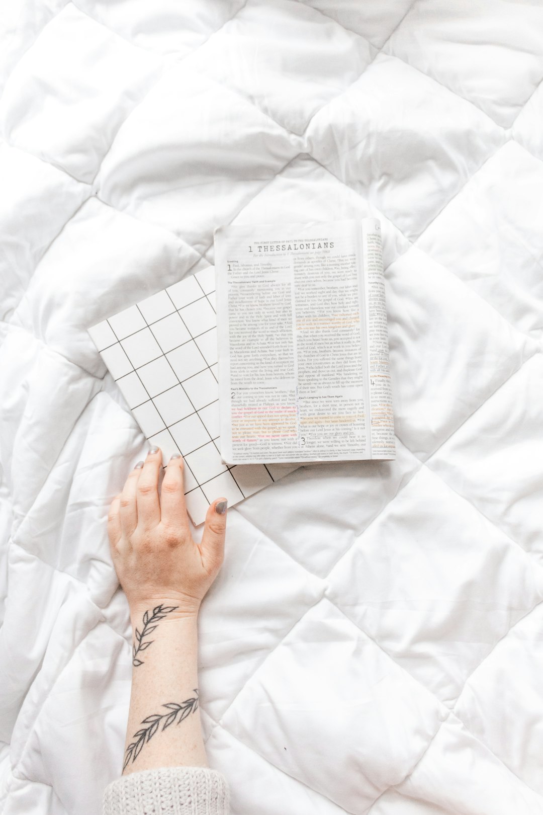 person holding white printer paper on white textile