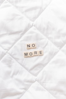 a close up of a white quilt with words written on it