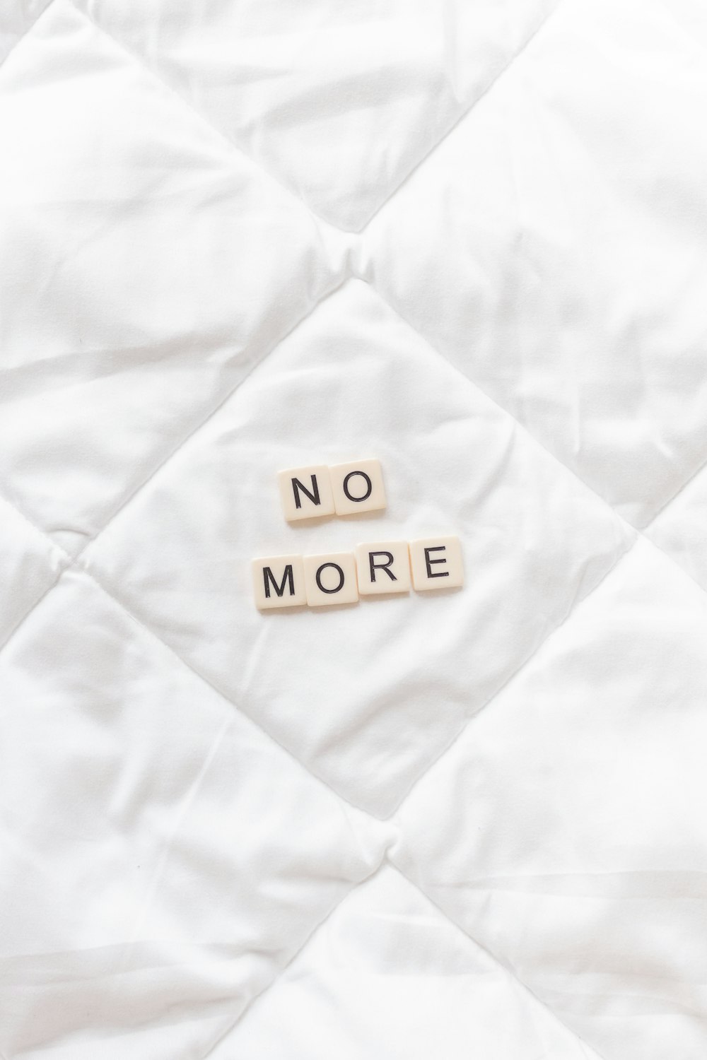 a close up of a white quilt with words written on it