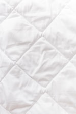 a close up of a white quilted material