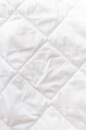 a close up of a white quilted material