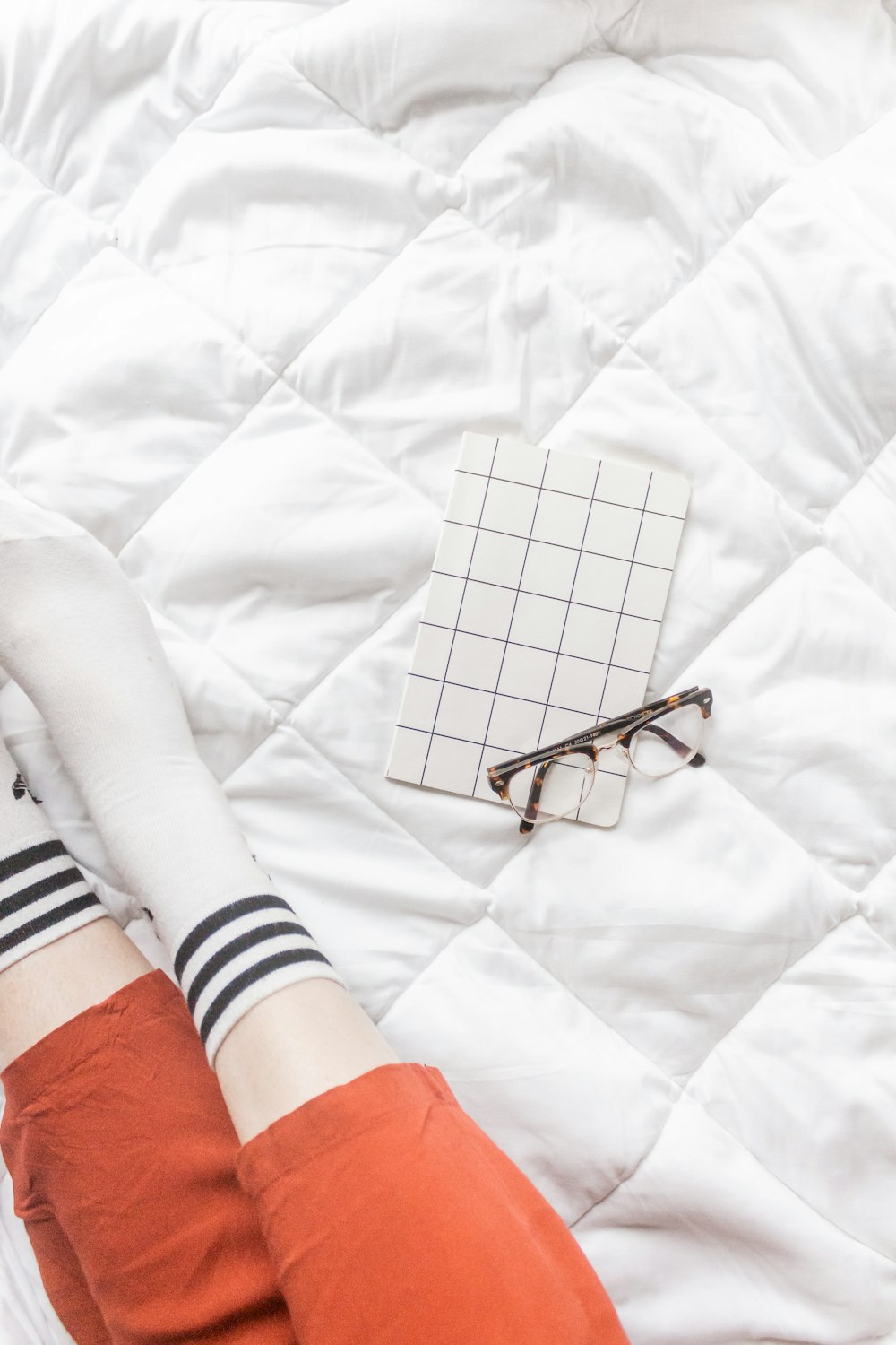 a person laying on a bed with their legs crossed