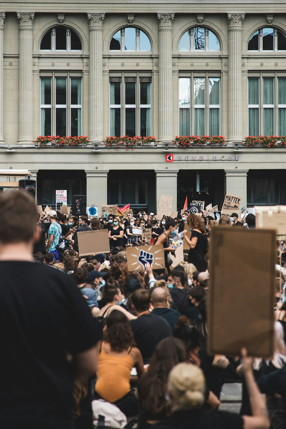 people gathering in front of white concrete building during daytime