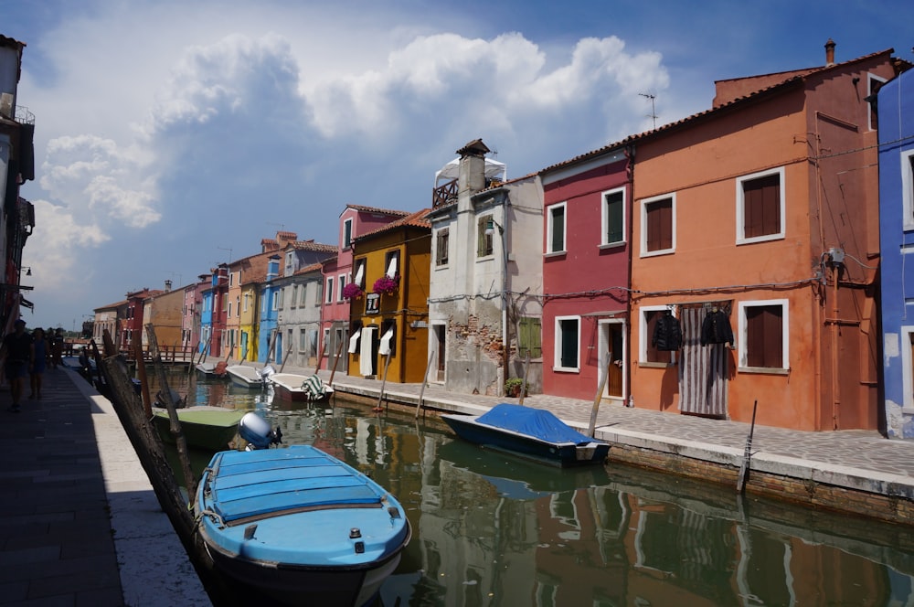 blue boat on water near concrete buildings during daytime