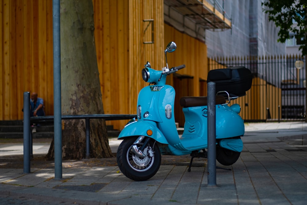 blue and black motorcycle parked beside brown wooden post