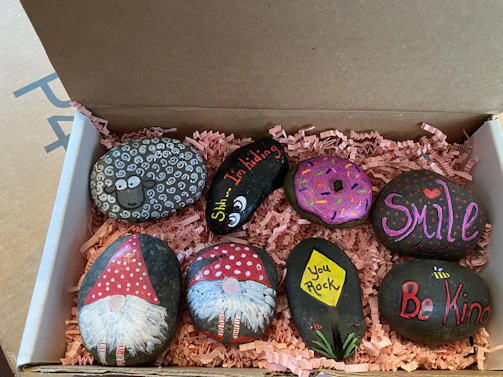 Children laughing as they paint colorful kindness rocks to spread around the neighborhood.