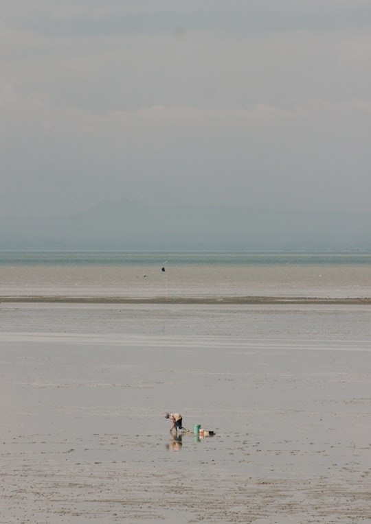 2 person walking on beach during daytime in Jembatan Nasional Suramadu Indonesia