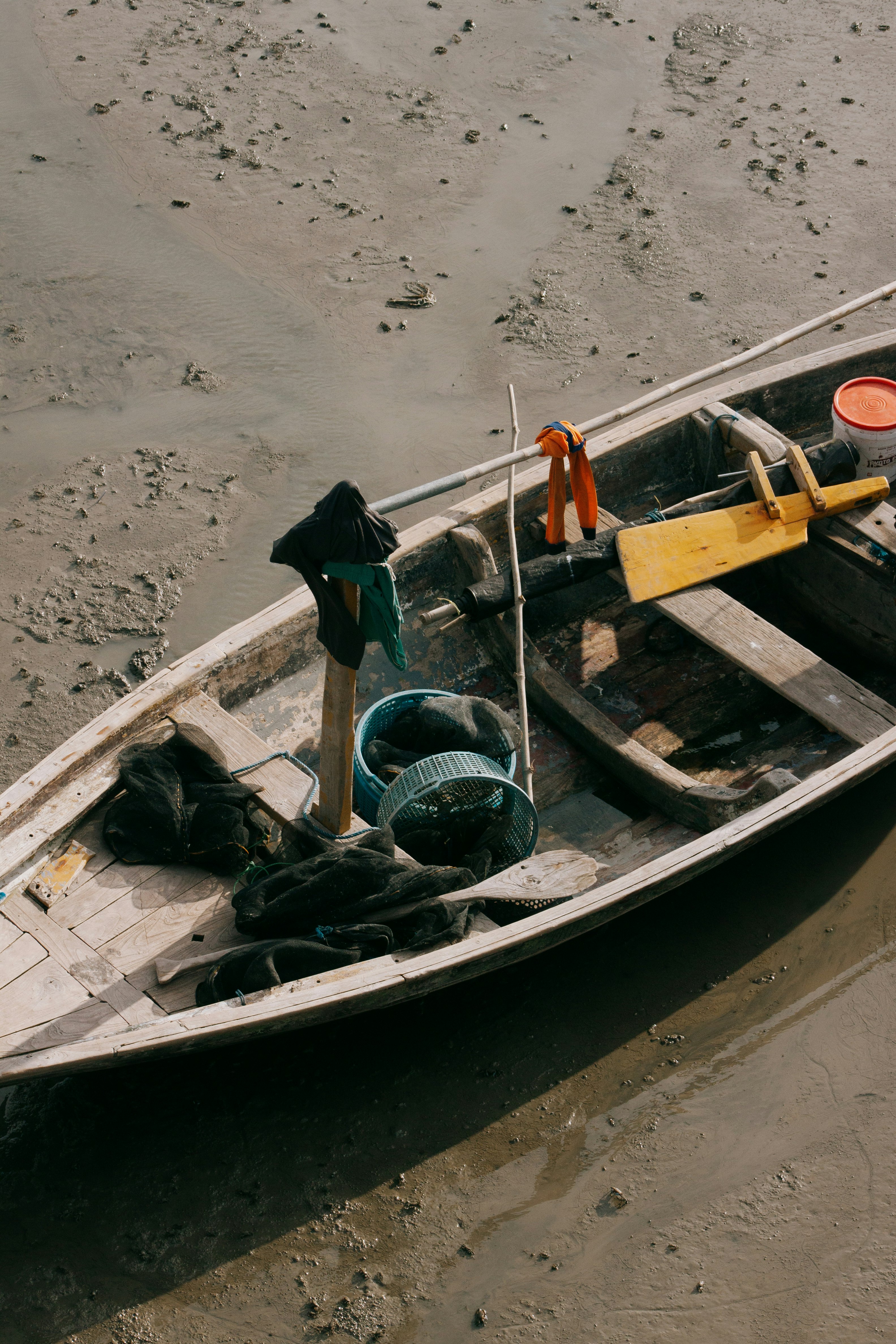 woman in black jacket and black pants standing on brown wooden boat on beach during daytime