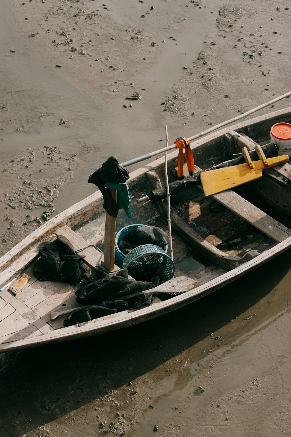 woman in black jacket and black pants standing on brown wooden boat on beach during daytime