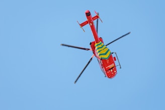 red and yellow helicopter flying in the sky