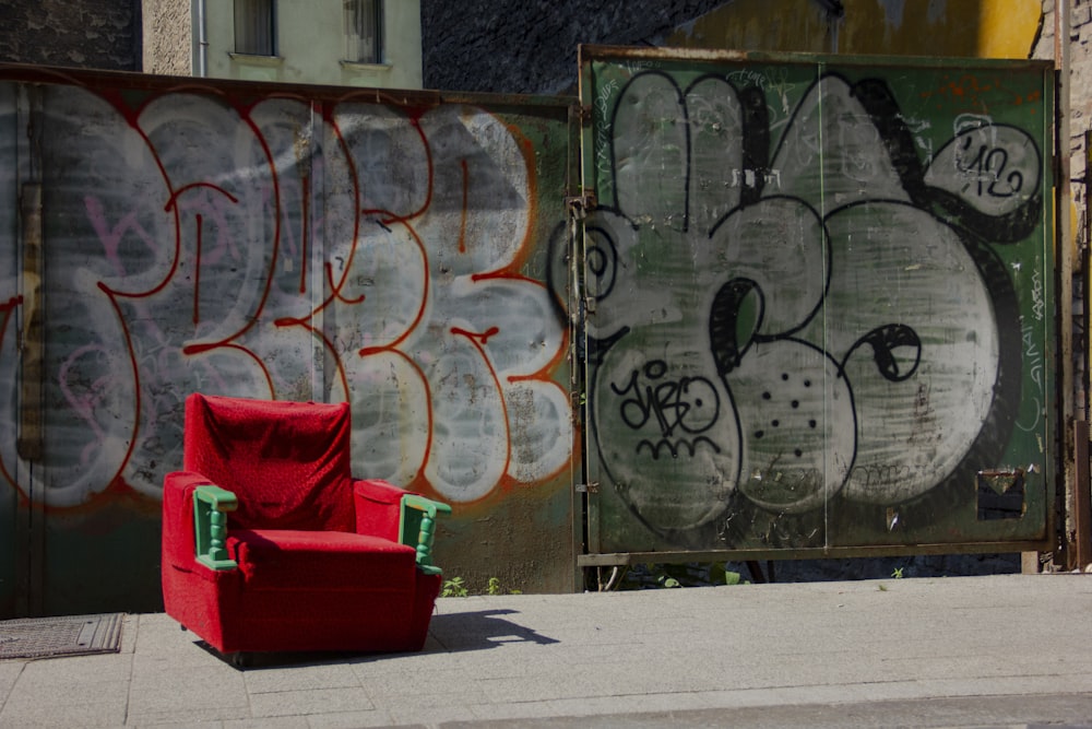 red sofa chair beside graffiti wall