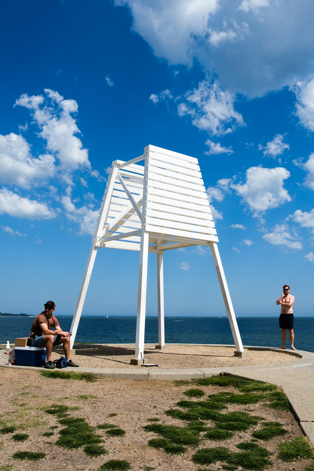 woman in black tank top sitting on brown wooden bench under blue sky during daytime