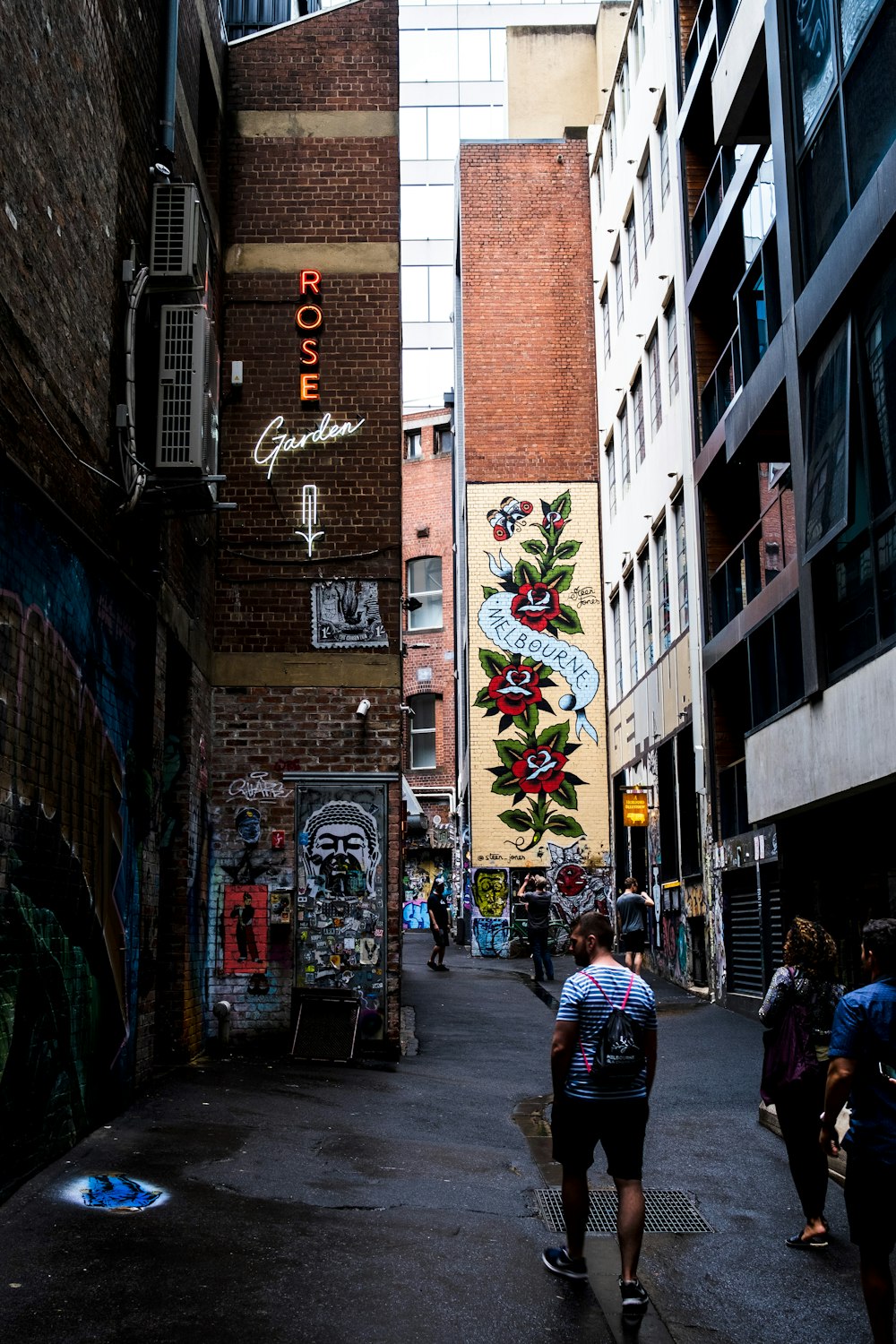 people walking on street between concrete buildings during daytime