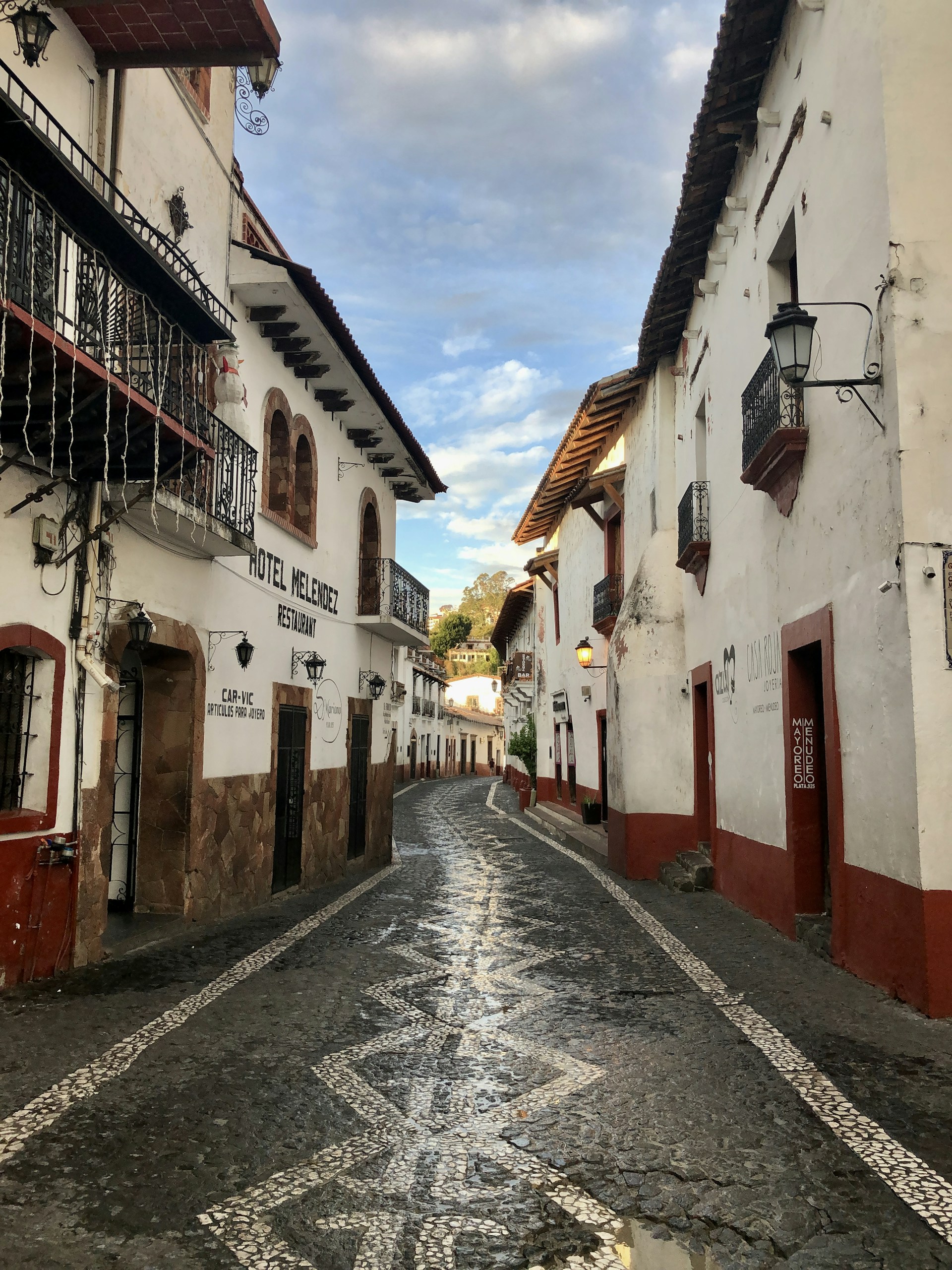 empty street between concrete houses under blue sky during daytime
