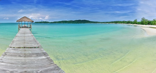 brown wooden dock on sea under blue sky during daytime in Koh Rong Sanloem Cambodia