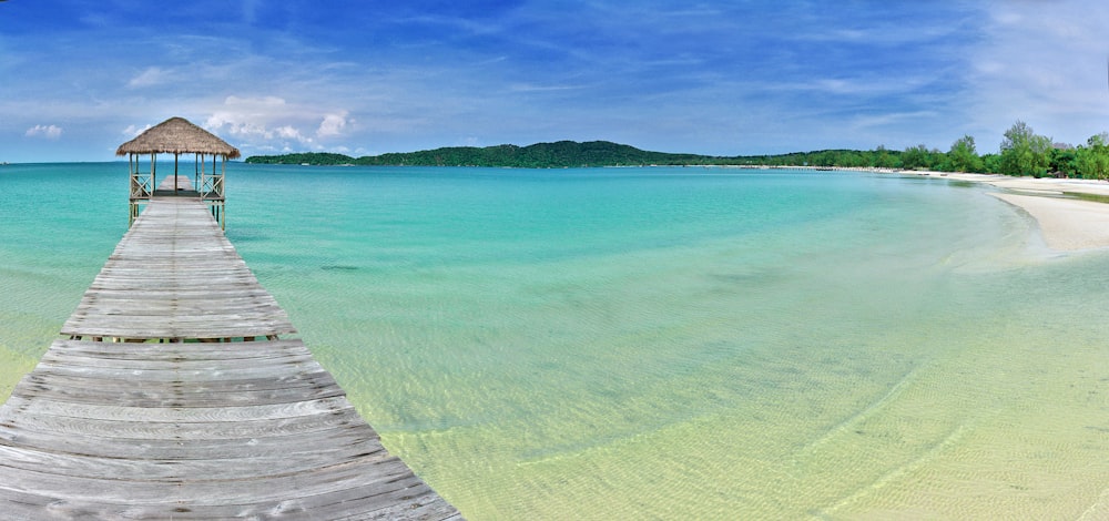 brown wooden dock on sea under blue sky during daytime