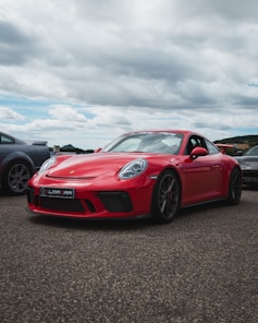 red ferrari 458 italia on gray asphalt road under gray cloudy sky