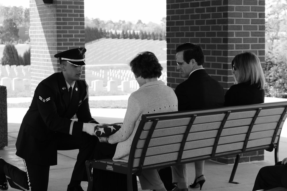 man in black suit sitting on bench