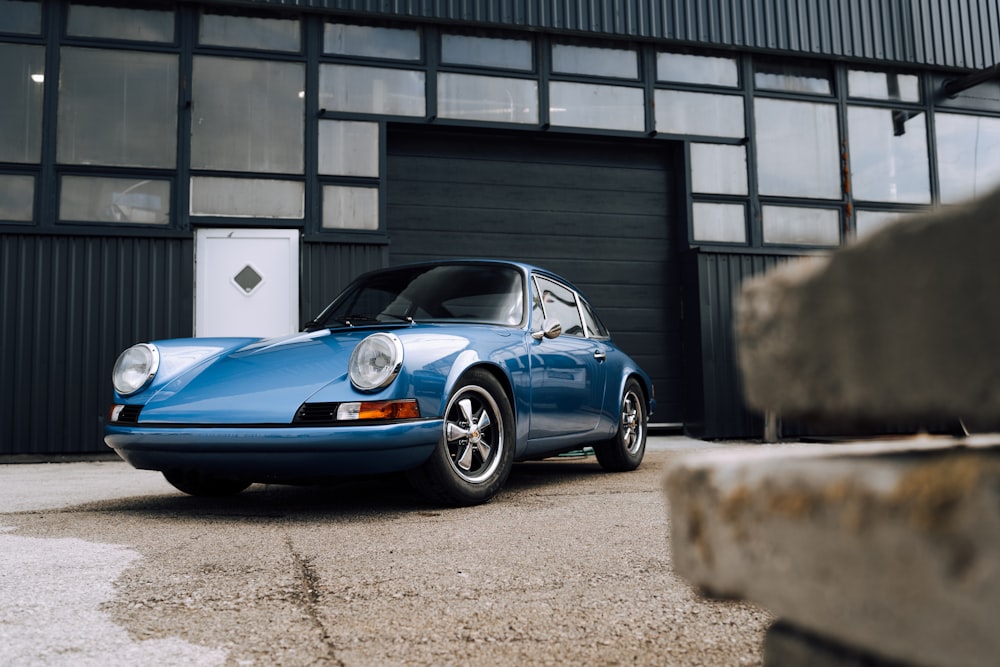 blue porsche 911 parked near building