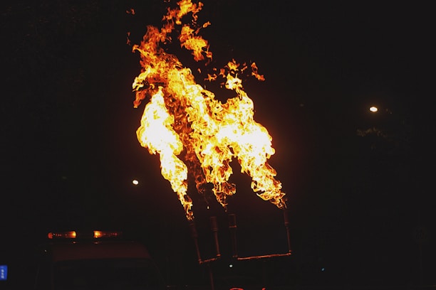Flames shooting up dramatically during a nighttime outdoor event.
