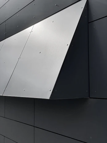 Close-up of modern aluminum composite panels being installed on a building facade.