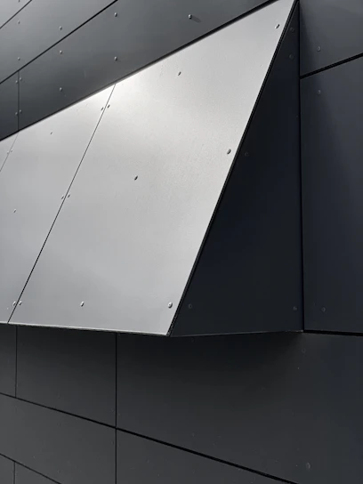 Close-up of a white EPS foam cornice with a smooth, reinforced coating installed on a sleek modern building facade.