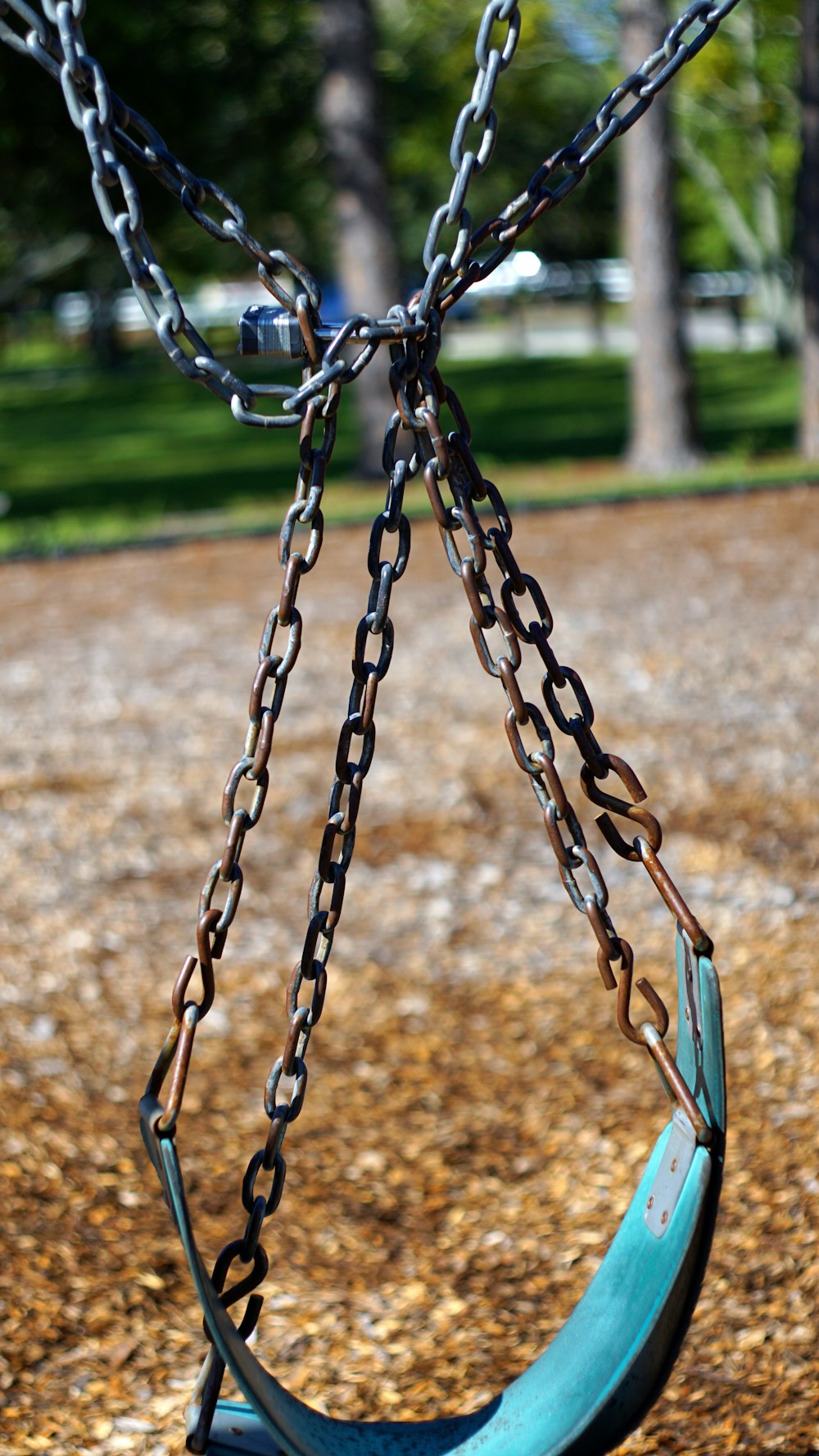 black metal swing on brown ground during daytime