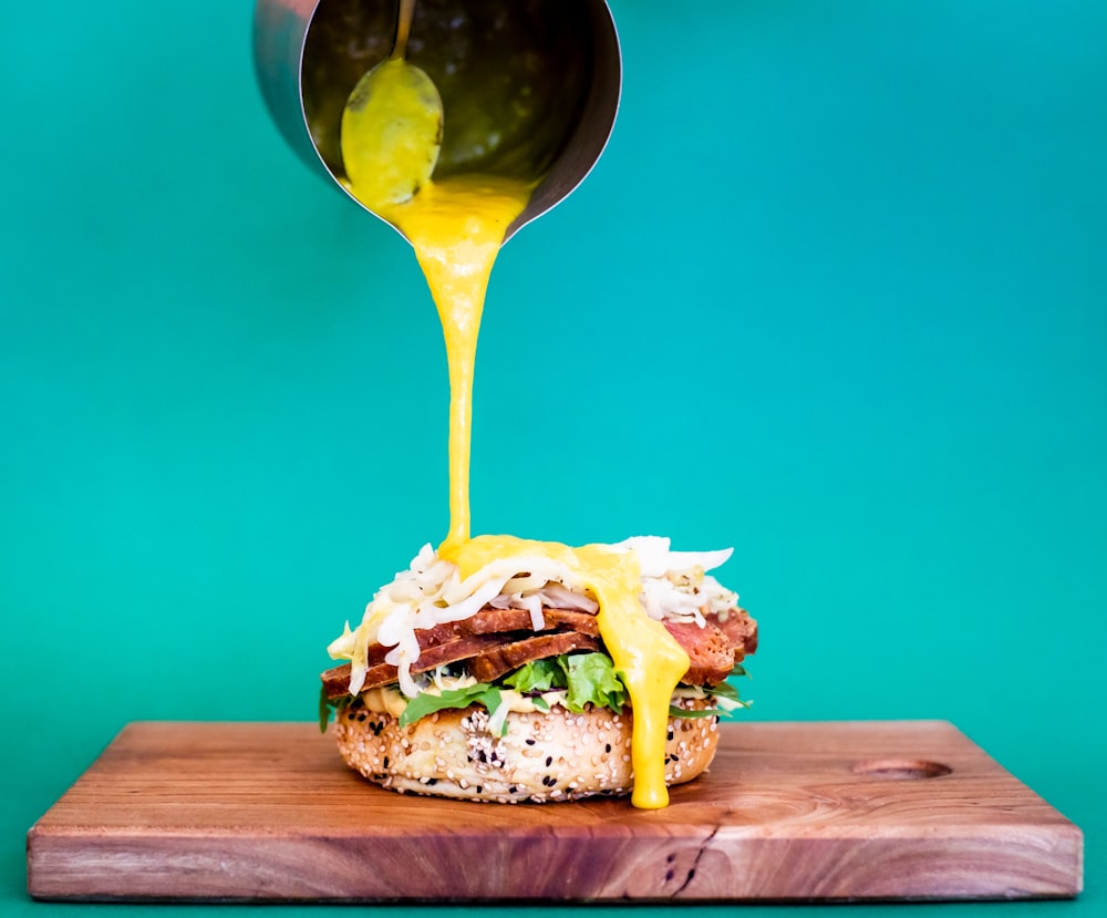 burger with cheese and lettuce on brown wooden table