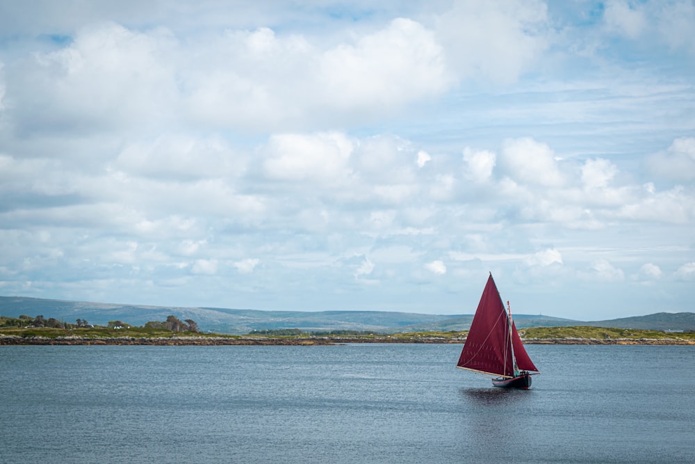 sailboat on sea under white clouds during daytime