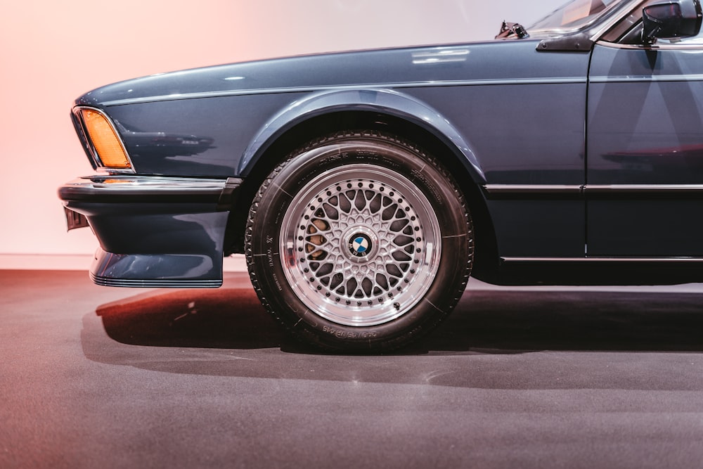 a blue car parked in a garage next to a wall