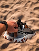 Close-up of hands holding a pair of rubber shoes, showing the flexible material.
