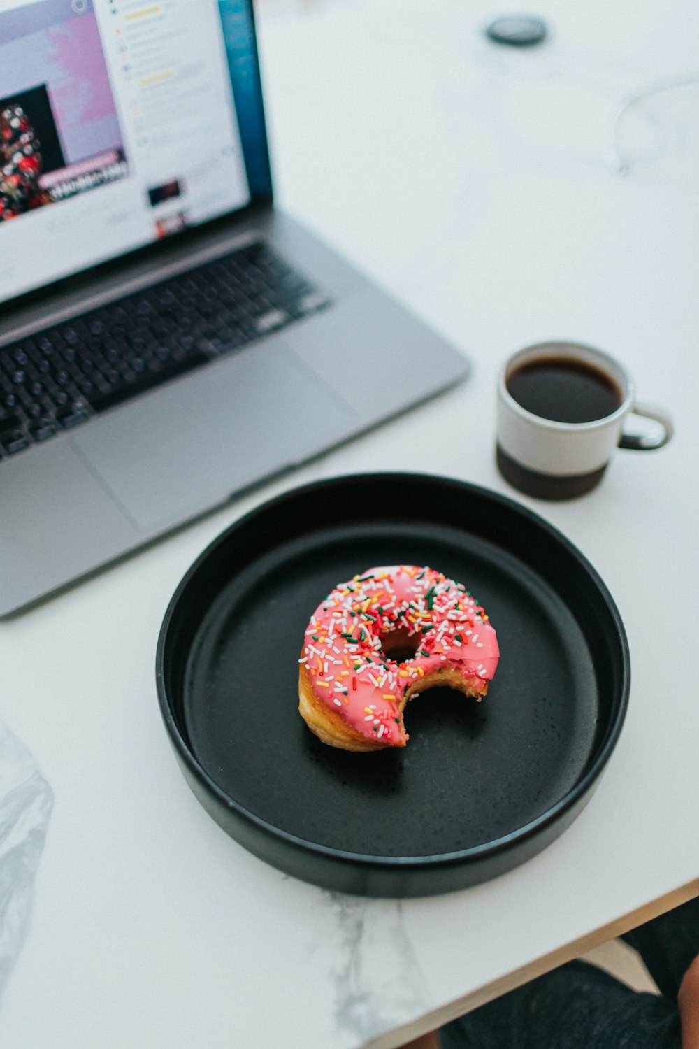 black round plate beside white ceramic mug on white table