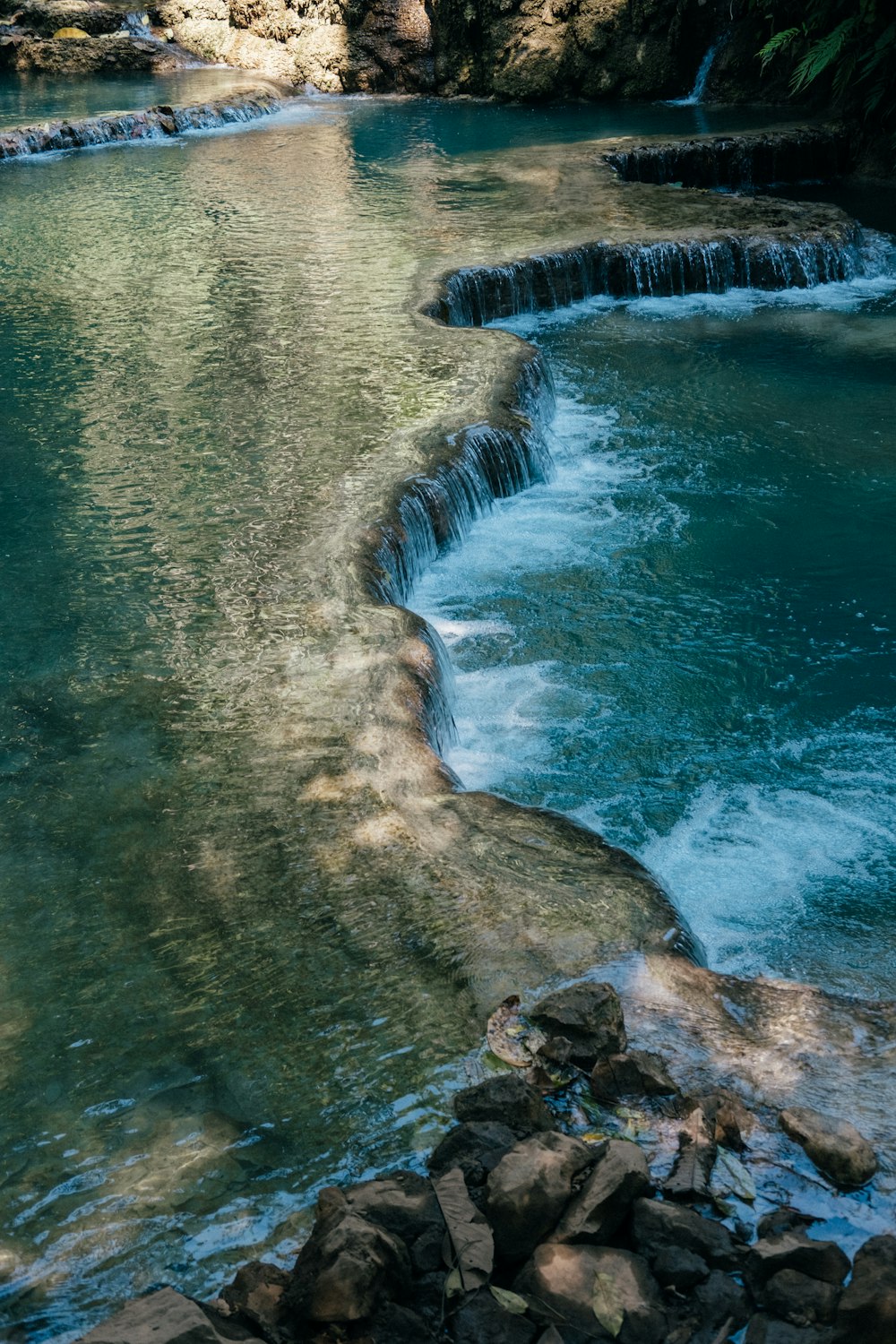 body of water near brown rock formation during daytime