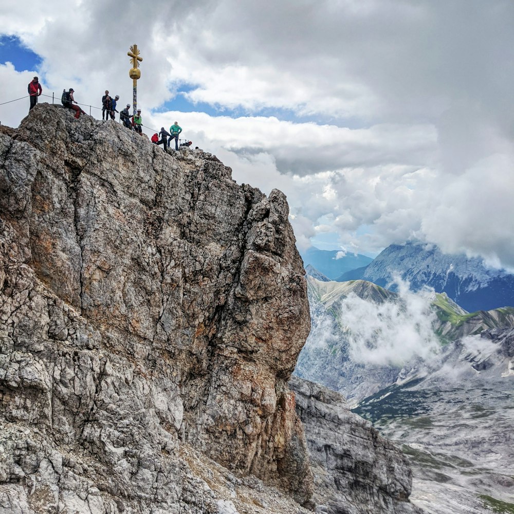 2 person standing on rocky mountain during daytime