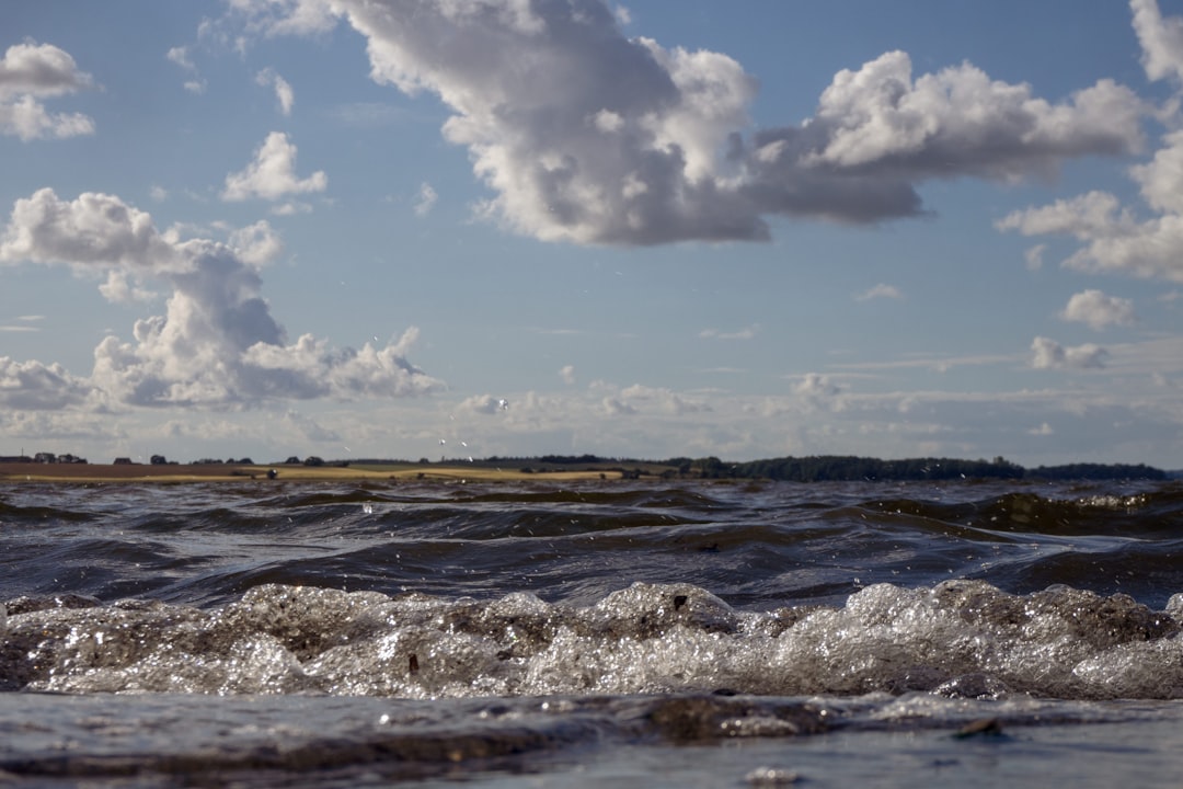 ocean waves under blue sky and white clouds during daytime