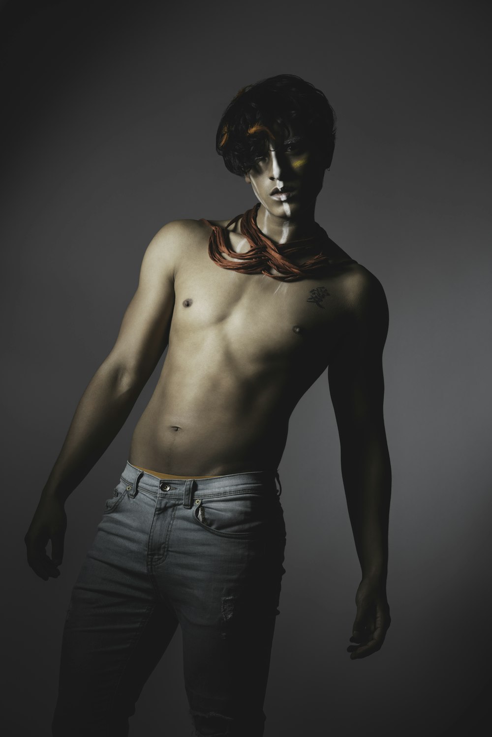 topless man in blue denim jeans with black mask