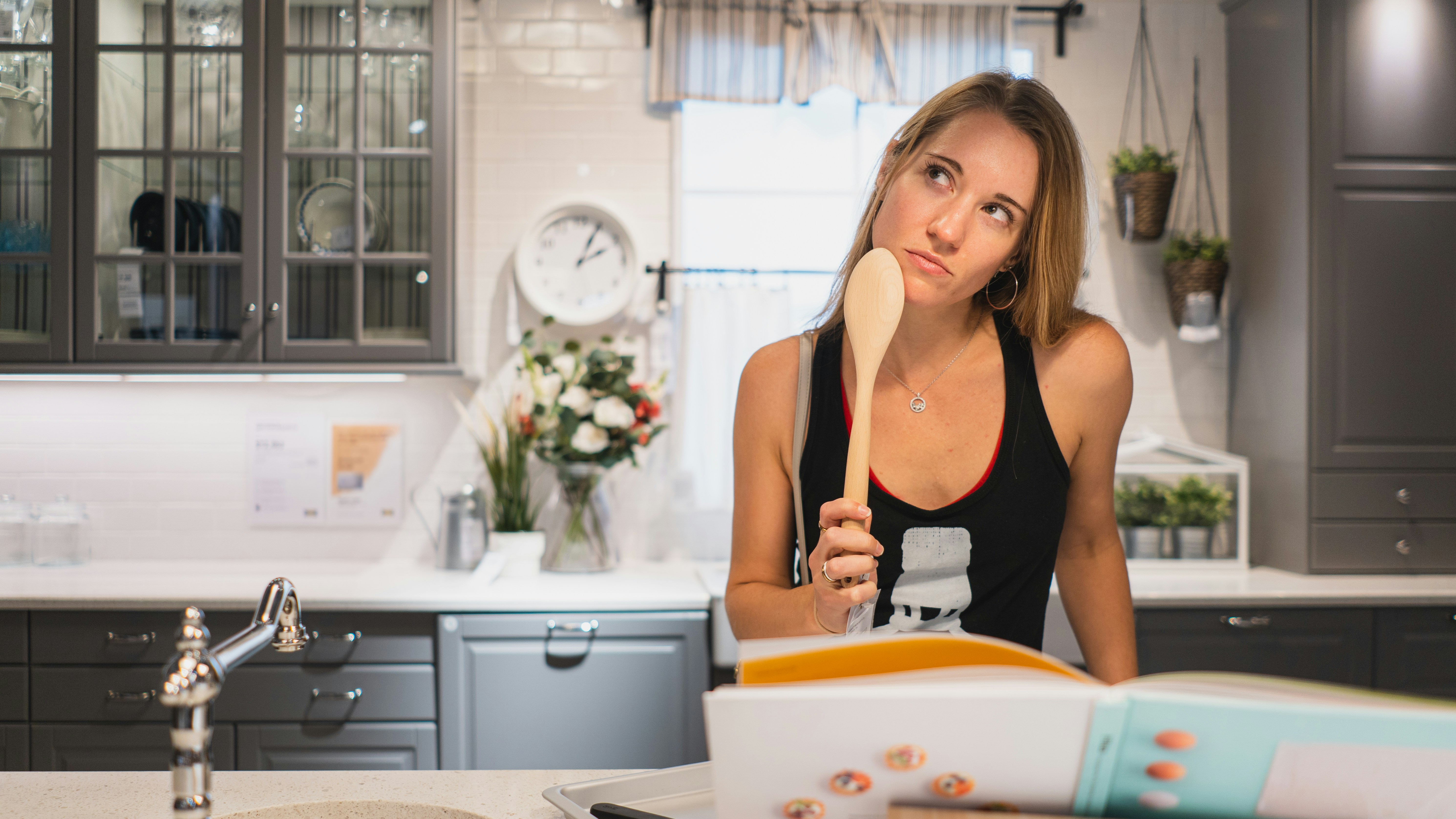 Woman in black tank top holding white ceramic plate