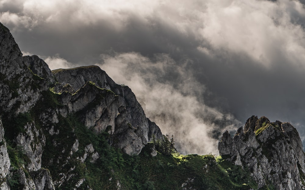 green and gray mountain under gray clouds