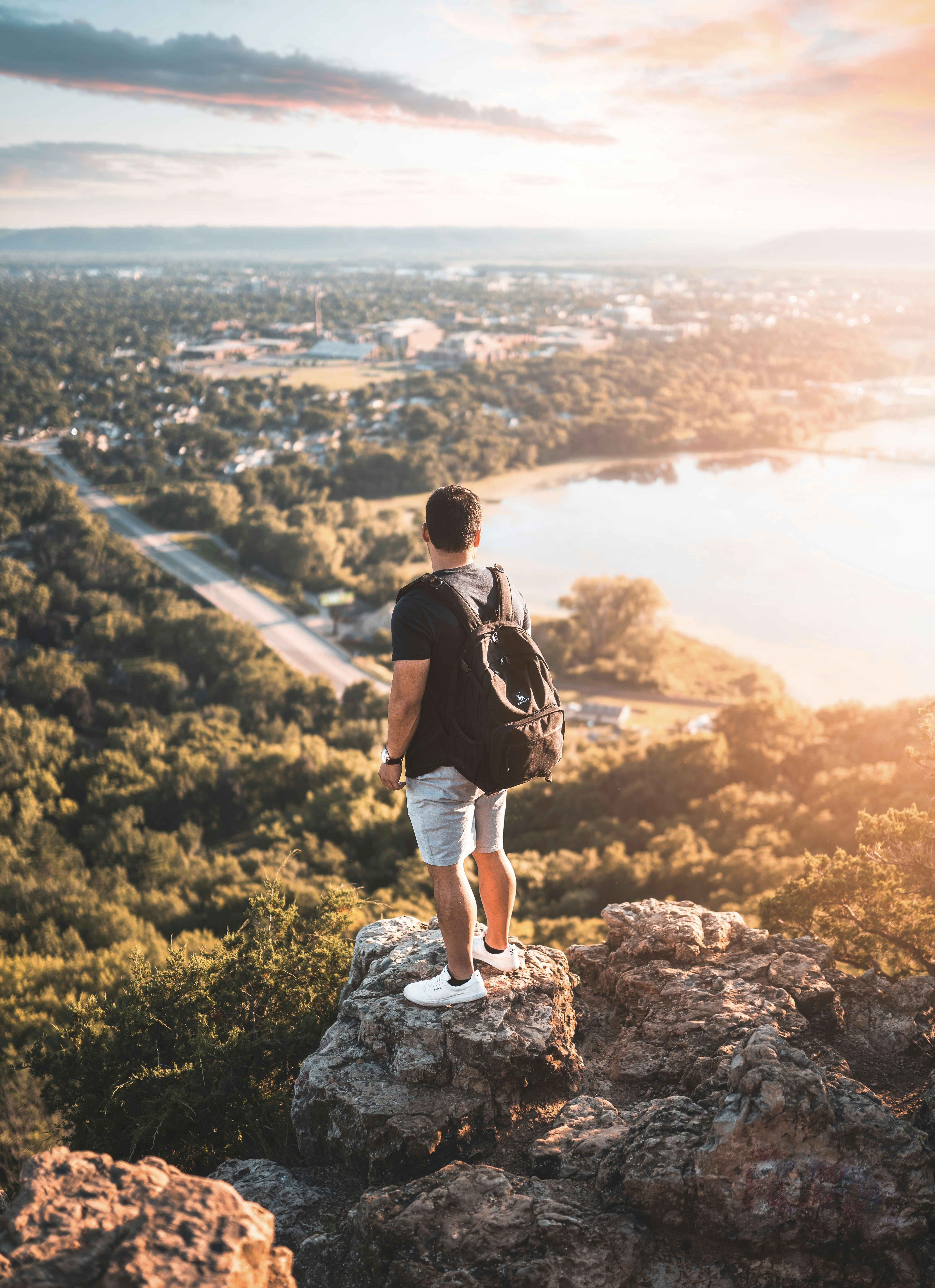 man in black t-shirt standing on rock during daytime